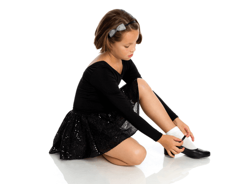 Young dancer putting on tap shoes
